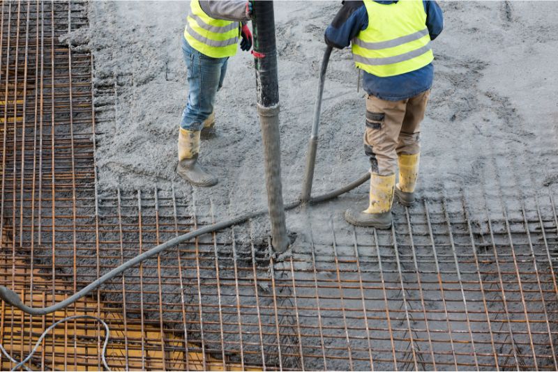 A photo of men pouring concrete to a mesh