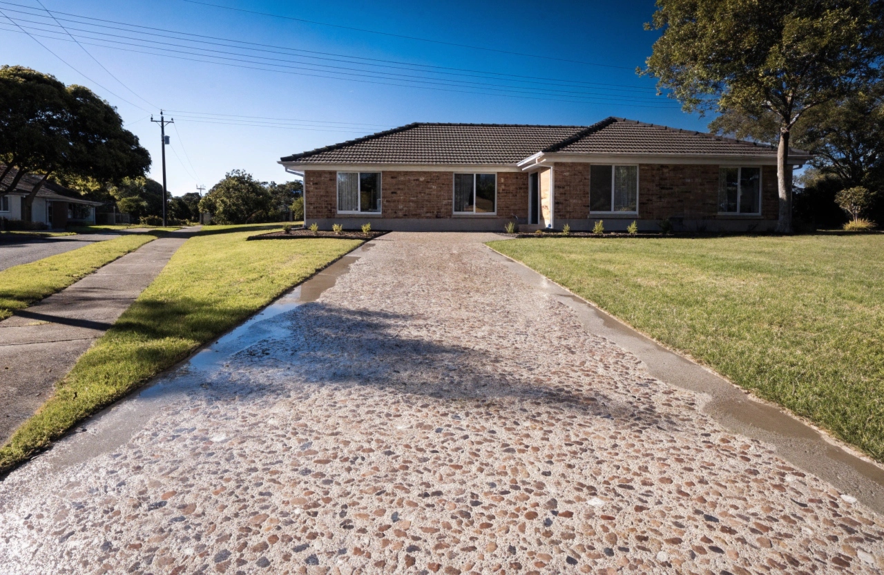 wide-shot-of-a-newly-poured-exposed-aggregate-conc Exposed aggregate concrete driveway at a residential home in Eli Waters Hervey Bay